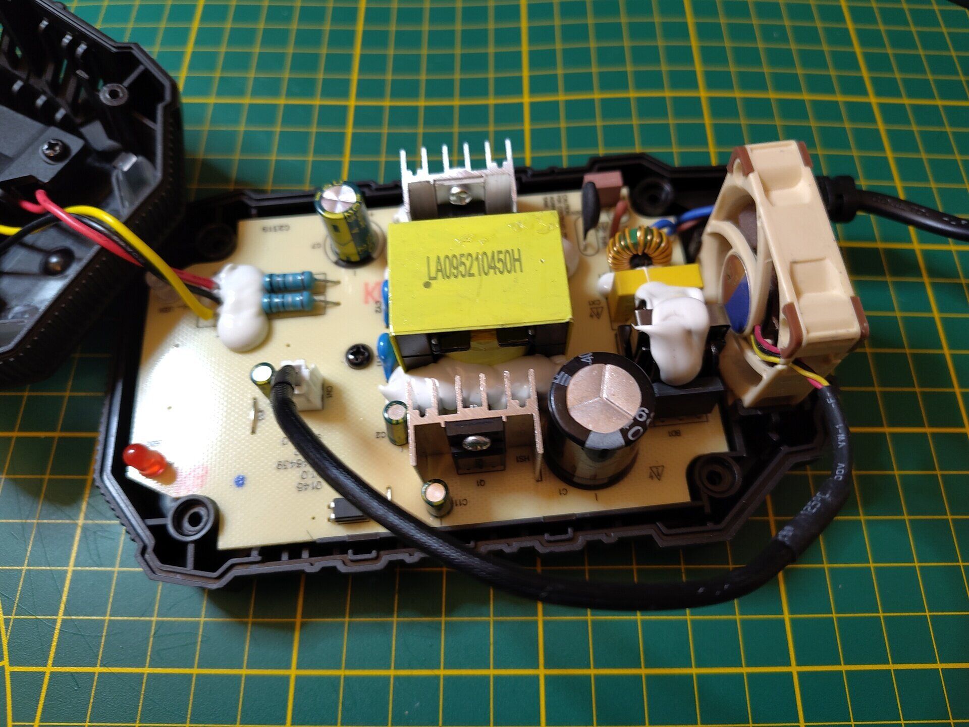 Shows the Parkside 20V Charger with the 4Ax10 Noctua fan placed in the fan slot and the wire routed next to the capacitator